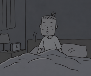 暗い寝室で布団から起き上がる子ども